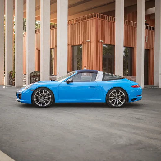 Яркая машина стоит рядом с современным зданием на улице в ясный день