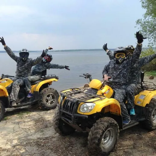 Группа людей на квадроциклах наслаждается дальним отдыхом у водоема в ясный день