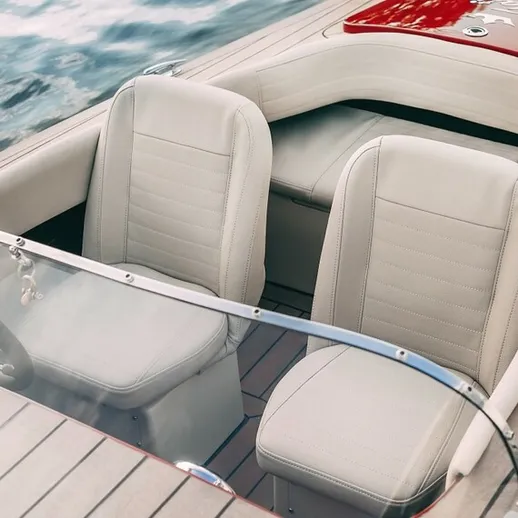 Современная моторная лодка с белыми сиденьями на спокойной воде в солнечный день