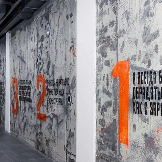 Внутреннее оформление коридора в арт-пространстве с яркими граффити и текстами о военном опыте