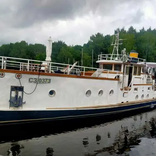 На реке находится старинное судно, плывущее среди зелёных лесов в облачную погоду