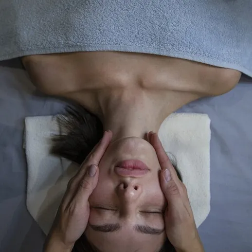 Сеанс массажа лица в спа-салоне во время релаксационной процедуры