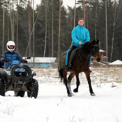Наездник на лошади и человек на квадроцикле в зимнем лесу, Россия