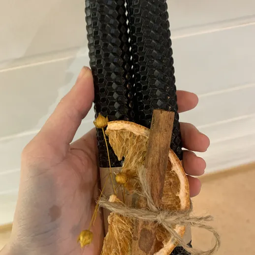 Свечи из воска с апельсином и корицей на фоне белой стены