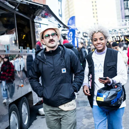 Молодежь наслаждается атмосферой городской ярмарки с уличной едой и развлечениями