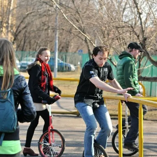 Молодежь катается на самокатах и моноколесе в городском парке весной