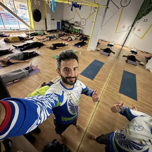 Групповое занятие по йоге в фитнес-центре, участники выполняют практику на ковриках в спокойной обстановке