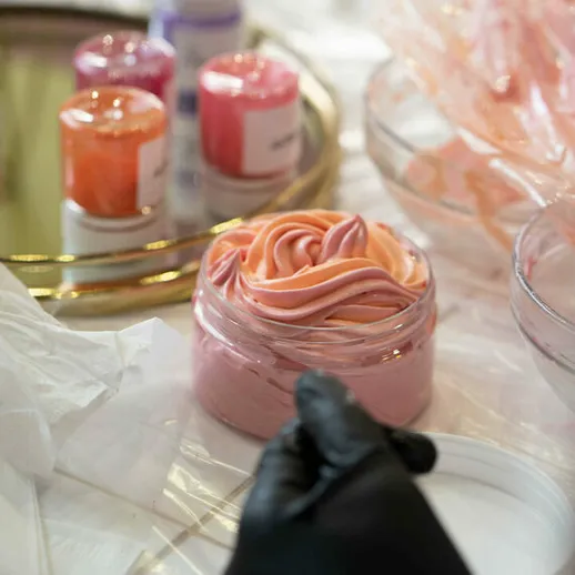 Мастерская по созданию косметики, где изготавливают крем с розовыми и персиковыми оттенками на столе