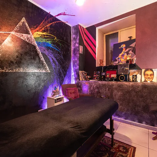 Уютный интерьер тату-студии с оригинальным дизайном стен и комфортным столом для клиентов