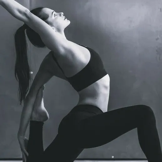 Фитнес-занятие в студии: девушка выполняет сложную асану йоги