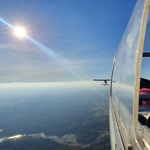 Полет на лёгком самолёте над живописным ландшафтом в ясный солнечный день
