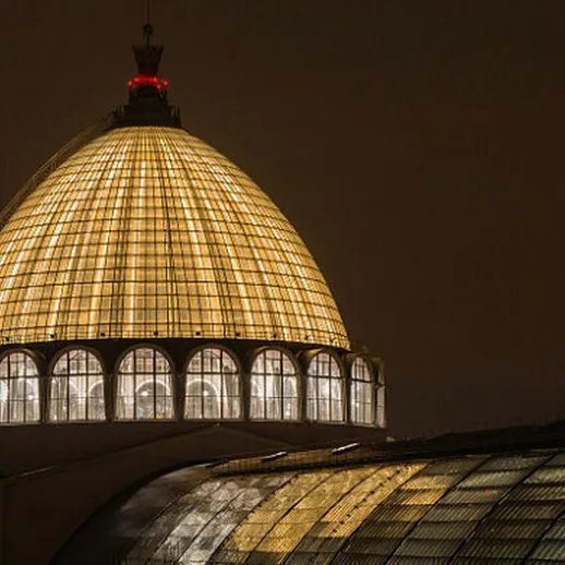 Золотой купол здания ярко освещён в ночное время над Москвой