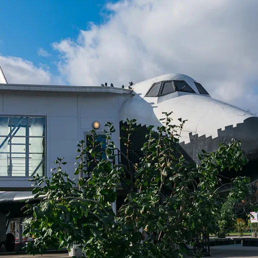 Спутник в парке: космический челнок во дворе музея на солнечном дне