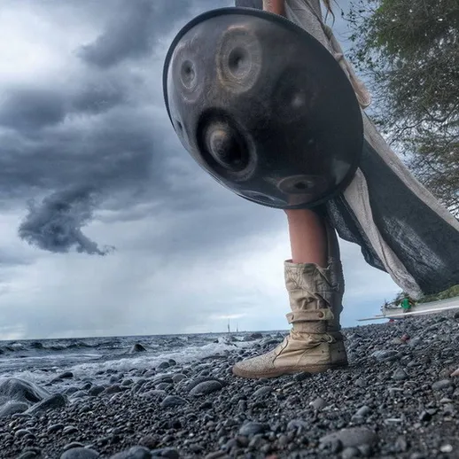Человек с ручным инструментом на берегу моря под облачным небом в вечернее время