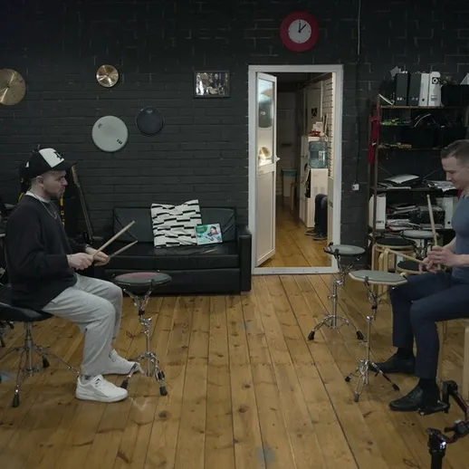 Два музыканта репетируют на ударных инструментах в студии звукозаписи