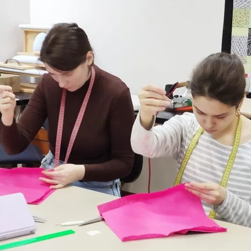 Учащиеся занимаются пошивом одежды на занятии по шитью в художественной школе