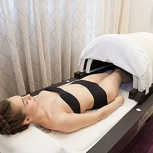 Женщина на процедуре массажа в спа-салоне, окруженном занавесками, расслабляющая атмосфера и уход за телом