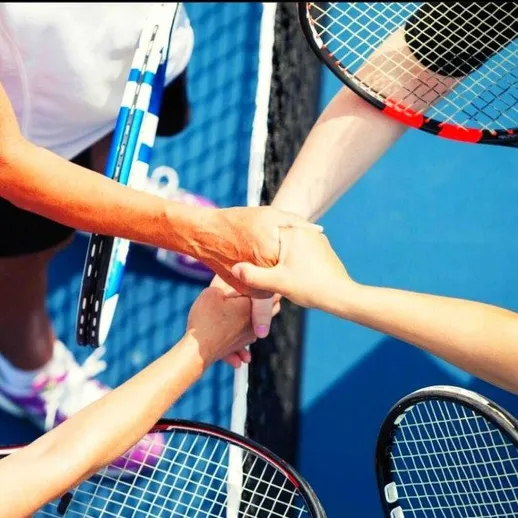 Сплоченная команда теннисистов обсуждает стратегию на корте во время соревнования в солнечную погоду