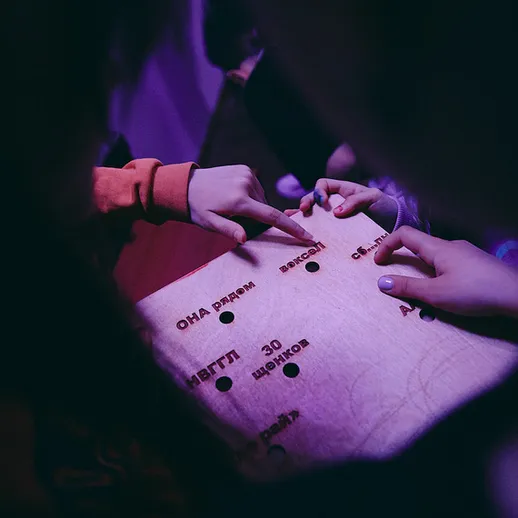 Люди играют в настольную игру в темной комнате, исследуя возможности и взаимодействуя друг с другом