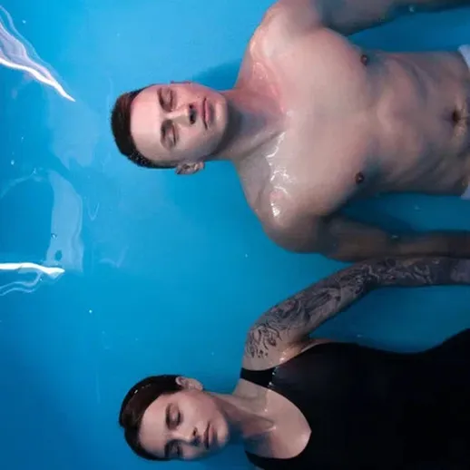 Пара на фоне голубой воды, расслабляясь и наслаждаясь моментом подводной гармонии