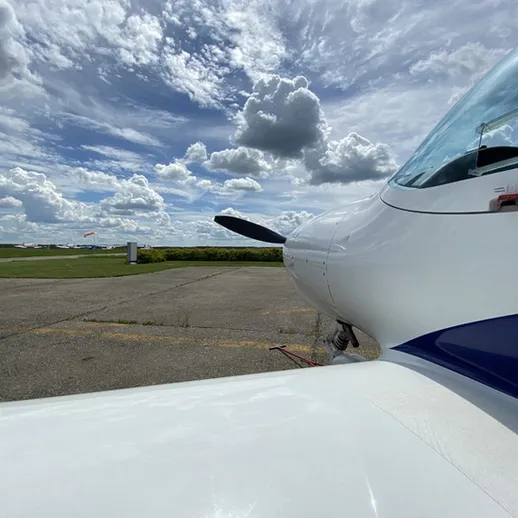 Авиационный летательный аппарат на аэродроме в солнечный день с облаками
