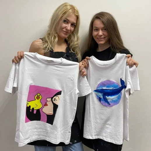 Две женщины демонстрируют футболки с оригинальными рисунками в студии в свободное время