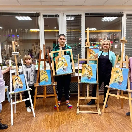 Группа людей показывает свои картины на выставке в художественной школе