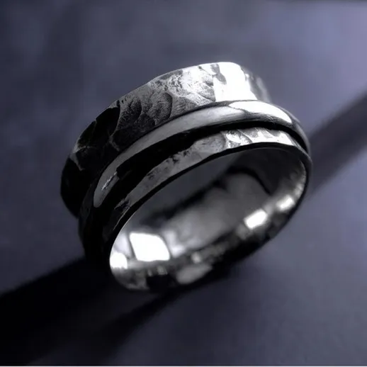 Элегантные кольца из серебра на темном фоне, с отражением света, подчеркивающим текстуру и дизайн