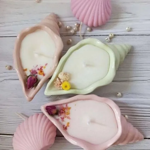 Свечи в форме раковин на деревянном фоне