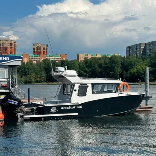 Водный транспорт стоит на причале в городе, на фоне зданий и неба