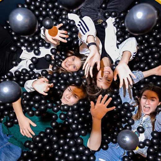 Дети играют в шариках в игровом центре в конце дня, весело проводя время вместе