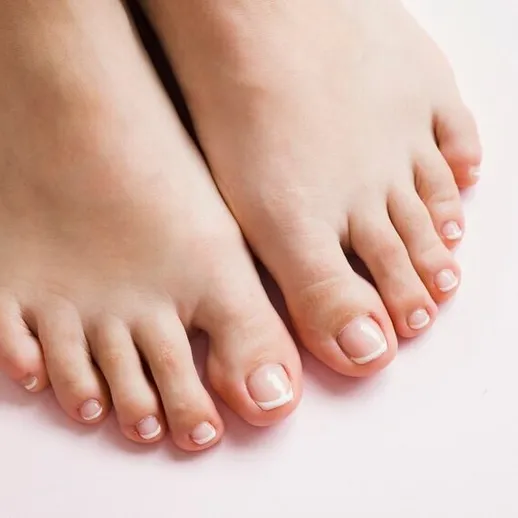 Подробный взгляд на ухоженные ноги, расслабляющиеся на светлом фоне в спокойной обстановке