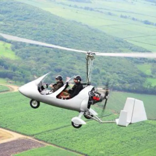 Полёт над зелеными полями на легкомоторном вертолете близ небольшого города, люди наслаждаются высотой и пейзажем