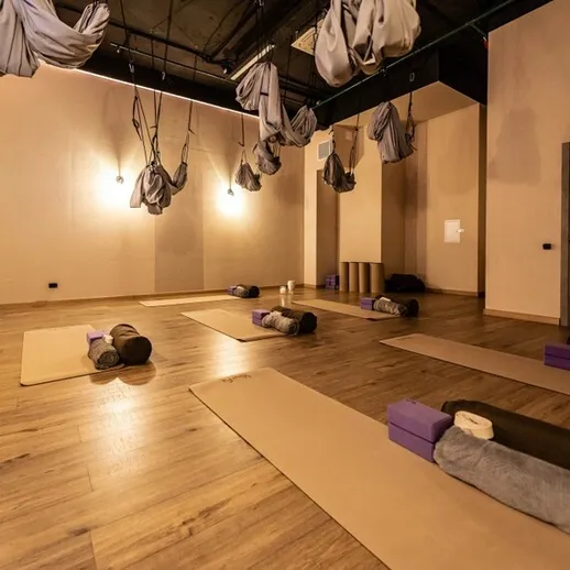 Студия йоги с висячими гамачками в спокойной атмосфере на занятии по антисгибу в утренние часы