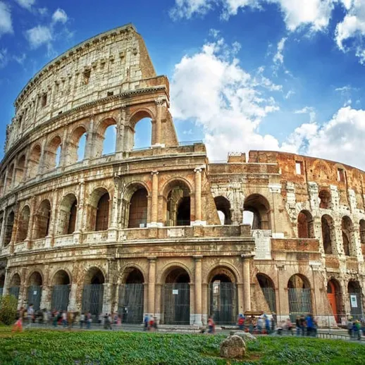 Костел и прохожие на фоне Колизея в Риме в ясный день