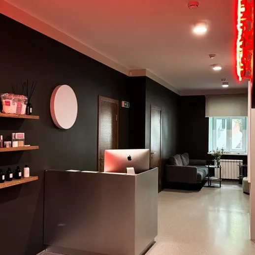 Уютный интерьер приемной современного салона в центре города, выполненный в темных тонах с мягким освещением