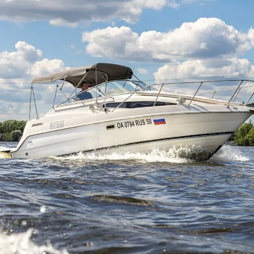 Водная прогулка на белом катере по реке в солнечный день с облаками