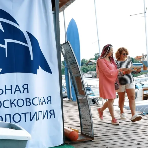 Две женщины прогуливаются по набережной у марины, наслаждаясь летним днем в Москве