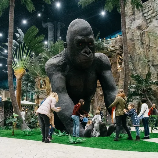 Большая статуя гориллы в развлекательном центре, где семьи взаимодействуют с представлением природы и фантазии
