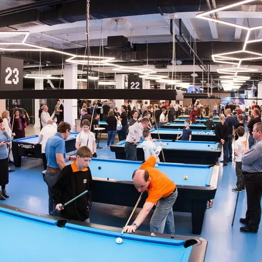 Соревнование по бильярду в современном зале в центре города, участники соревнуются в вечернее время