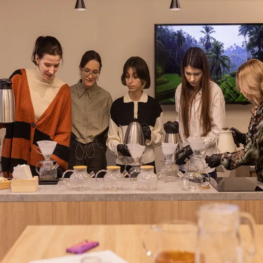 Женщины готовят кофе в уютной кофейне на мастер-классе по баристике