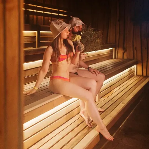 Два человека сидят в сауне и отдыхают после занятий спортом