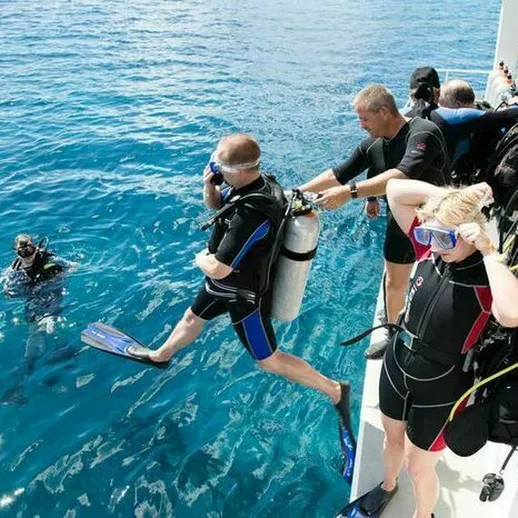 Группа дайверов готовится к погружению в кристально чистые воды тропического моря