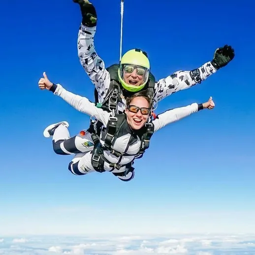 Скайдайвинг над живописным ландшафтом на высоте нескольких тысяч метров в ясный солнечный день