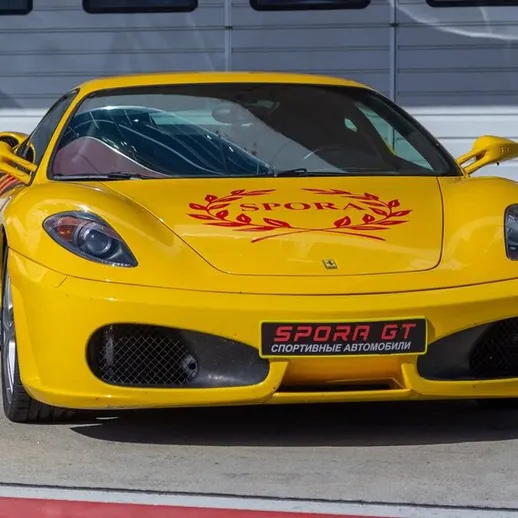 Ярко-желтый спорткар на автодроме, готовый к гонке под солнцем