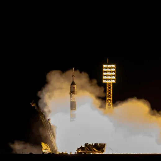 Запуск ракеты с космодрома во время ночного неба, мощный огонь и дым в воздухе