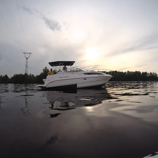 Яхта на спокойной воде под вечерним небом у берега реки