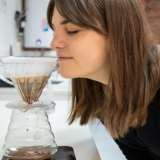 Женщина наслаждается ароматом свежезаваренного кофе в кафе