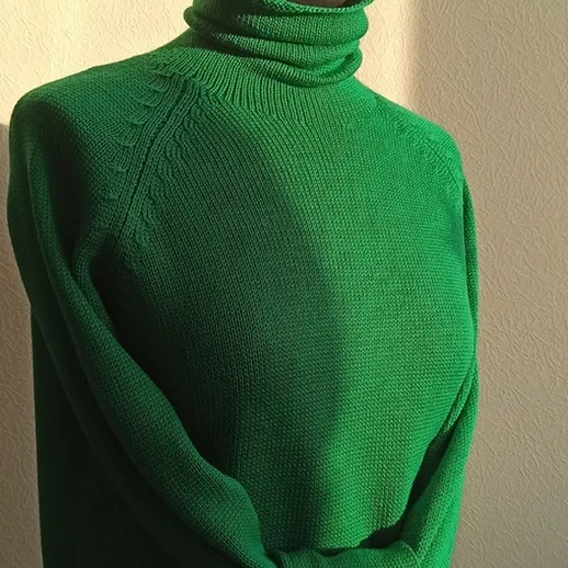 Теплый зеленый свитер на манекене в солнечном свете, создающем уютную атмосферу