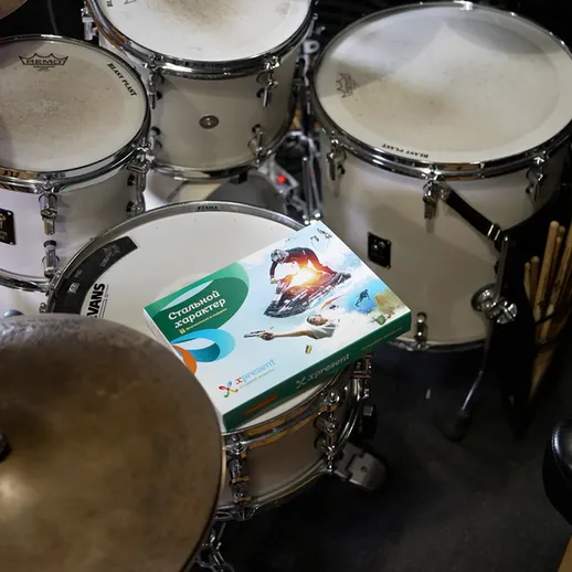 Установка барабанов в репетиционной студии с учебником по игре на ударных